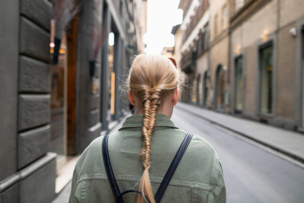 Tourist in the City Rear view of a woman with a braid in her hair travelling in Florence, Italy. travel destinations 20s adult adventure stock pictures, royalty-free photos & images