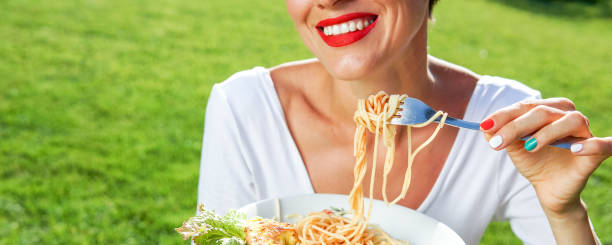 istock Young brunette woman eating spaghetti 1205765898