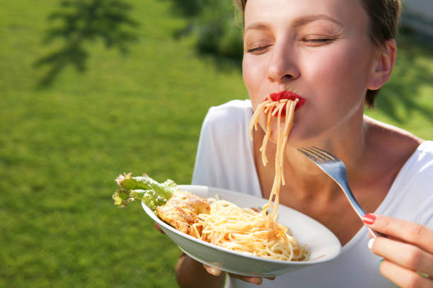 istock Young brunette woman eating spaghetti 1205765920
