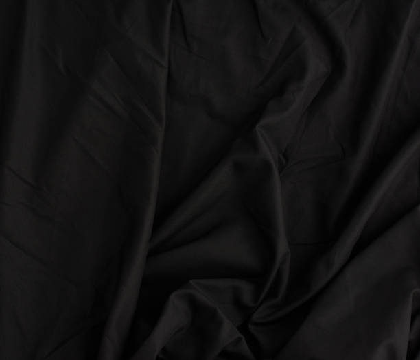 istock texture of black cotton fabric with waves, full frame 1205766504