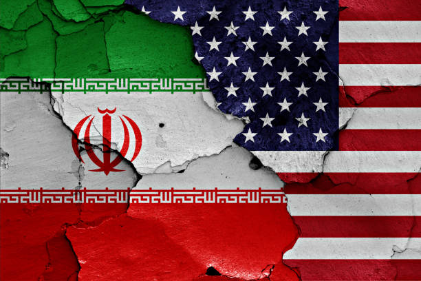 istock flags of Iran and USA painted on cracked wall 1205768409