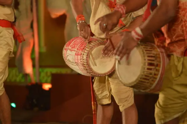 artist perform with indian music instrument 'Dhol' in open stage festival,DHOL also known as drum is made up of wood and leather ,can produce a nice beating sound with folk song 'Bihu' of assam,India