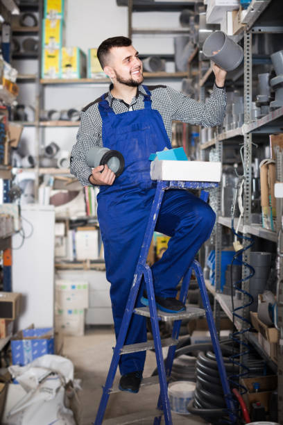 istock Young male worker examining plastic drain pipes 1205770034