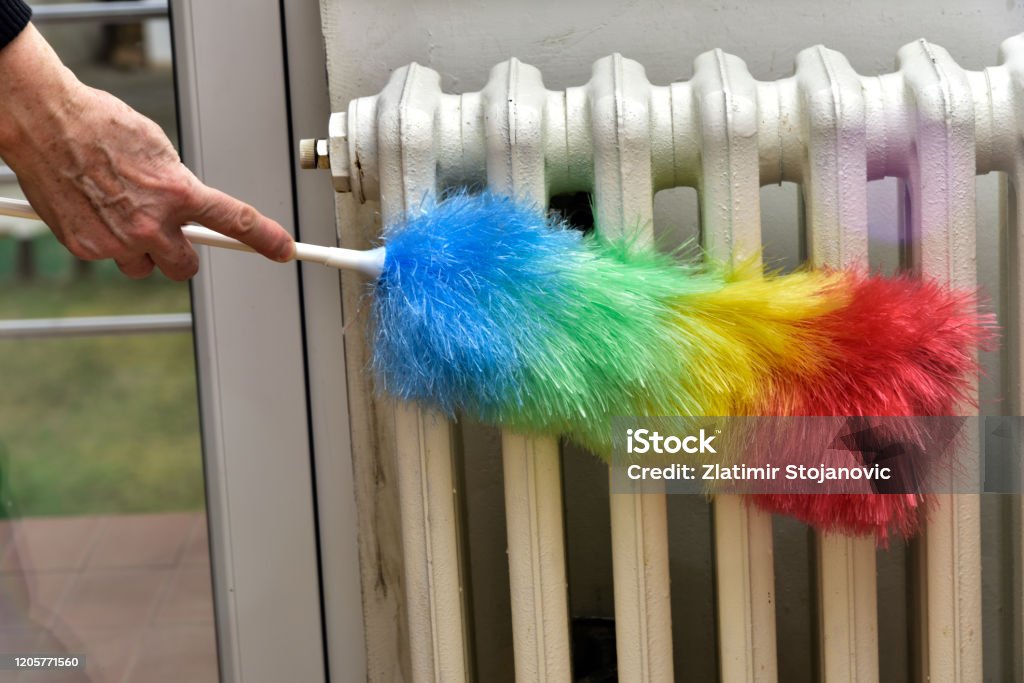 Cleaning A Radiator With A Brush From Dust Stock Photo - Download