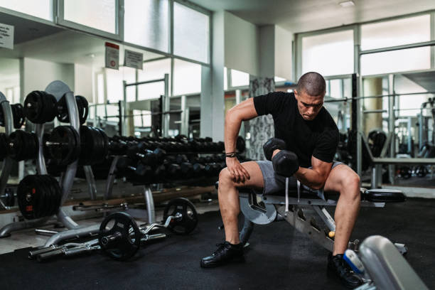 istock Man exercising and lifting weights in the gym 1205776782