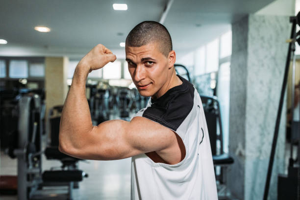 istock Man lifting weights and having a sports training in the gym 1205776958