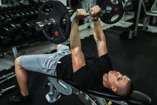 hombre haciendo ejercicio y levantando pesas en el gimnasio - body building gym human muscle effort fotografías e imágenes de stock