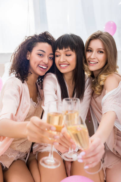 selektywne skupienie szczęśliwych wielokulturowych dziewcząt łączących się z kieliszkami szampana na wieczór panieński - bachelorette party zdjęcia i obrazy z banku zdjęć