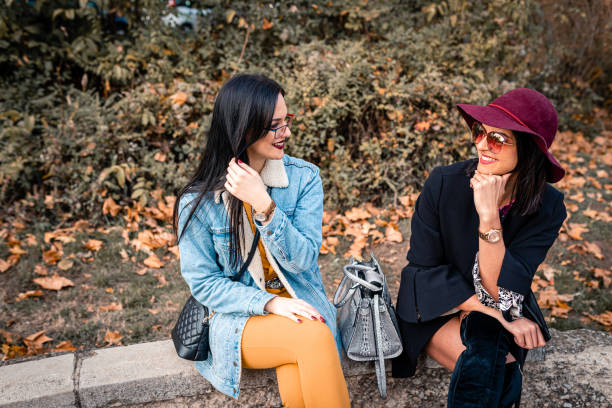 istock Two young women sitting in the park on a sunny day 1205779193