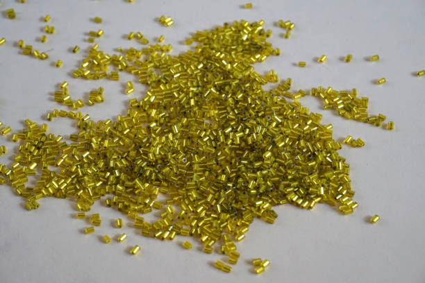 istock Yellow tubular toho beads on light cream background. 1205779282
