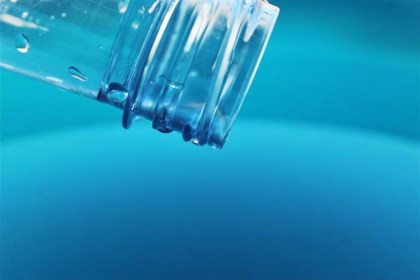 istock Rimmed plastic water bottle blue water background 1205779942