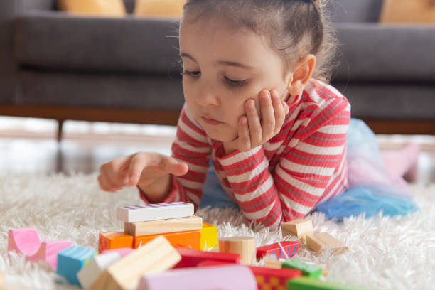 istock Little girl playing with toy blocks 1205780008