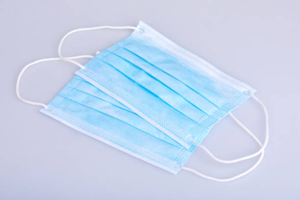 istock Two blue disposable face masks isolated on white background. 1205780152