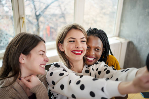 istock Beautiful young multi-ethnic women make selfies in cafe 1205782225