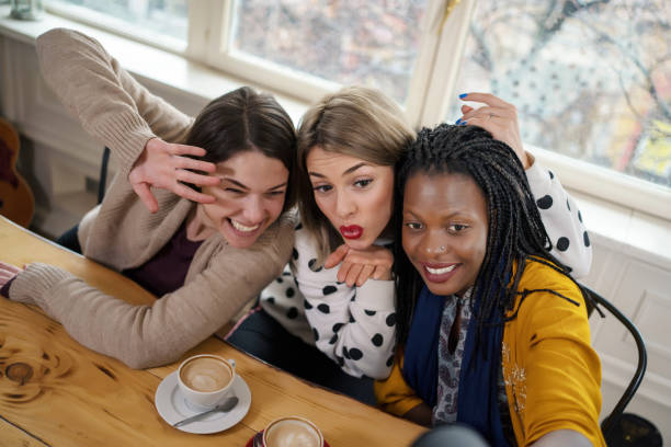 istock Beautiful young multi-ethnic women make selfies in cafe 1205782248