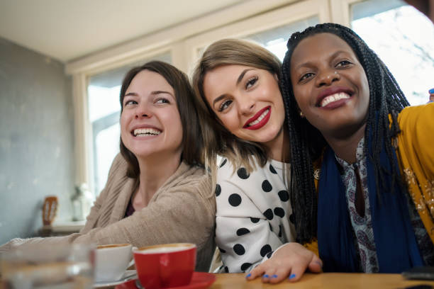 istock Beautiful young multi-ethnic women make selfies in cafe 1205782253