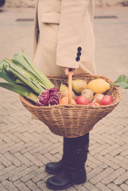 istock woman hold a wicker basket with fresh organic vegetables 1205787978