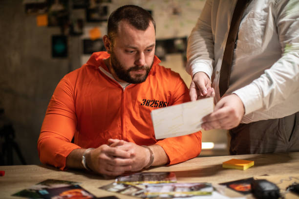 istock Prisoner with handcuffs being interviewed in interrogation room 1205789750