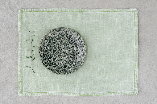 Green ceramic plate on linen placemat