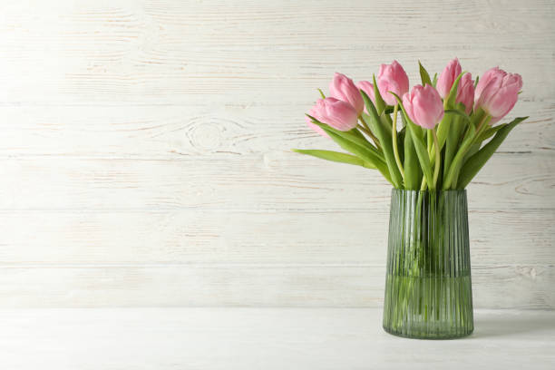 istock Vase with tulips on white wooden background, space for text 1205795076
