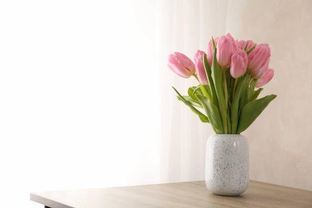 istock Tulips in vase on wooden background, space for text 1205795285