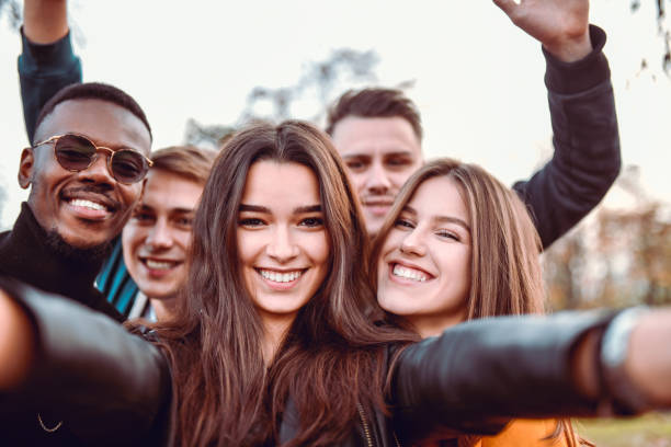 istock Smiling Friends Taking Selfie In Park 1205798276