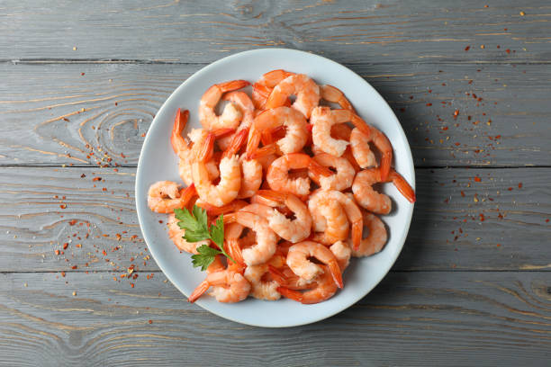 istock Plate with shrimps on wooden background, top view 1205799586