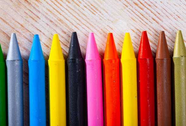 istock Multicolored crayon pencils on wooden surface 1205801397