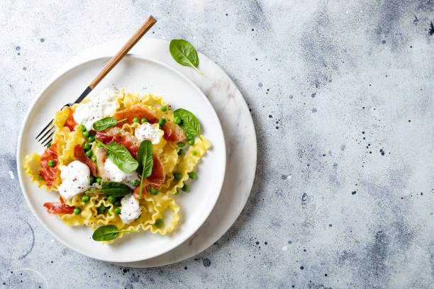 istock Italian pasta mafalde with green peas, prosciutto, burrata,  and spinach 1205802289