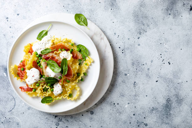 istock Italian pasta mafalde with green peas, prosciutto, burrata,  and spinach 1205802333