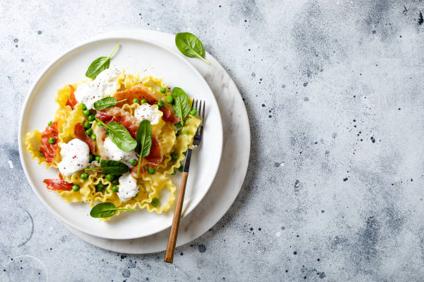 istock Italian pasta mafalde with green peas, prosciutto, burrata,  and spinach 1205802425
