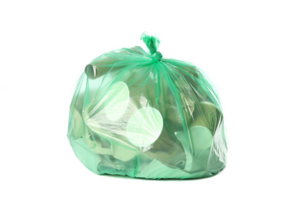 istock Green disposable bag with different trash isolated on white background 1205803489