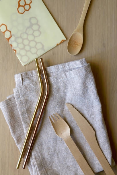 Zero Waste Kit Linen cloth, reusable straws, wooden cutlery and beeswax wrap on a wooden table. Set of zero waste kitchen products. Top view. beeswax wrap stock pictures, royalty-free photos & images