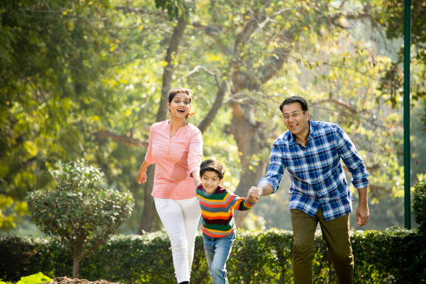 公園で遊ぶ女性と幸せな家族 - offspring family love india ストックフォトと画像