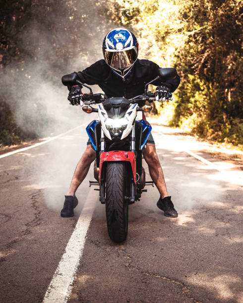 istock Guy riding a motorbike with agressive style and smoke behind him 1205806280