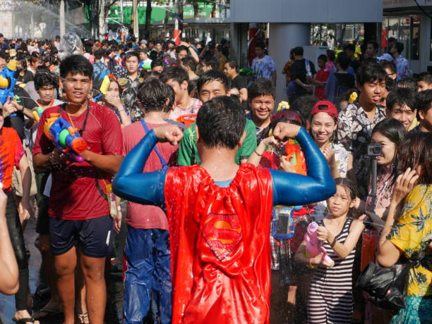 shooting water to the man, songkran - superman imagens e fotografias de stock