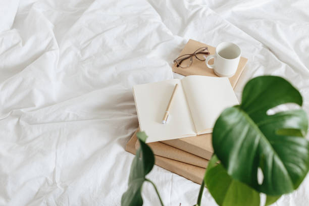 Books on bed white bed linen. stock photo