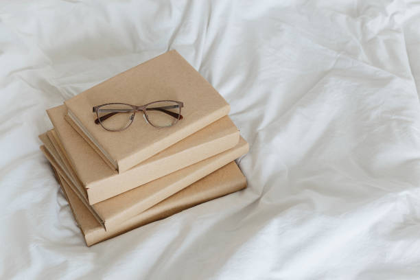 istock Books on bed white bed linen. 1205810430