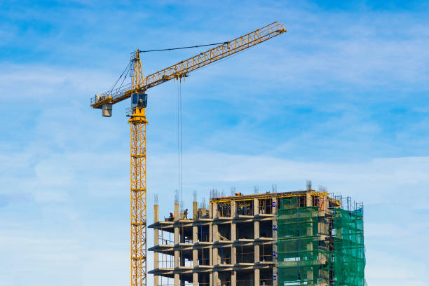 istock Tower crane and unfinished house against the blue sky. Construction site. Building 1205810692