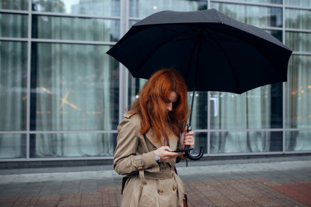 istock A Woman with Umbrella Walking on Rainy Day 1205811929