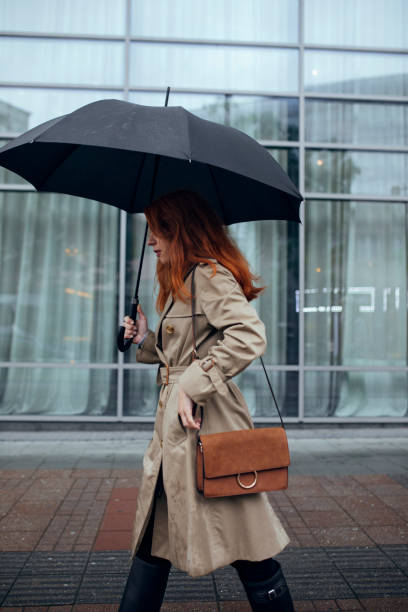 istock A Woman with Umbrella Walking on Rainy Day 1205811954