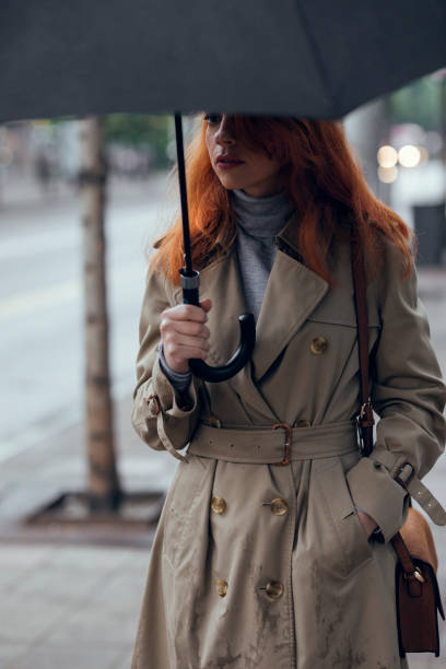 istock A Woman with Umbrella Walking on Rainy Day 1205811955