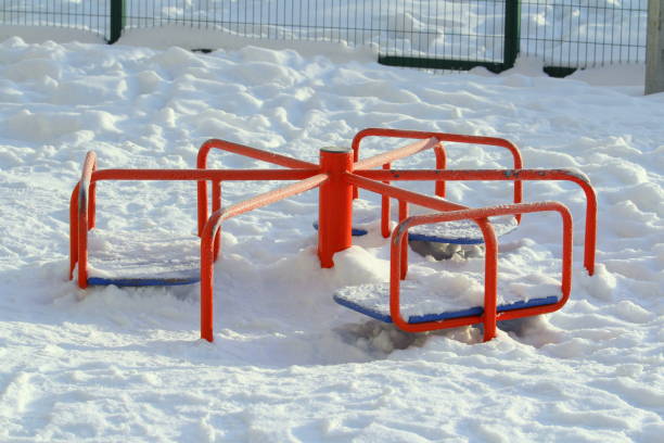 istock Children's red metal carousel covered with snow 1205811975