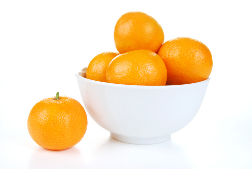 A bowl of fresh oranges in a white bowl