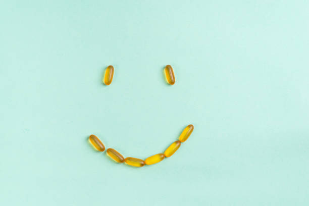 istock Omega 3 fish oil capsules smile isolated on a blue background 1205812062