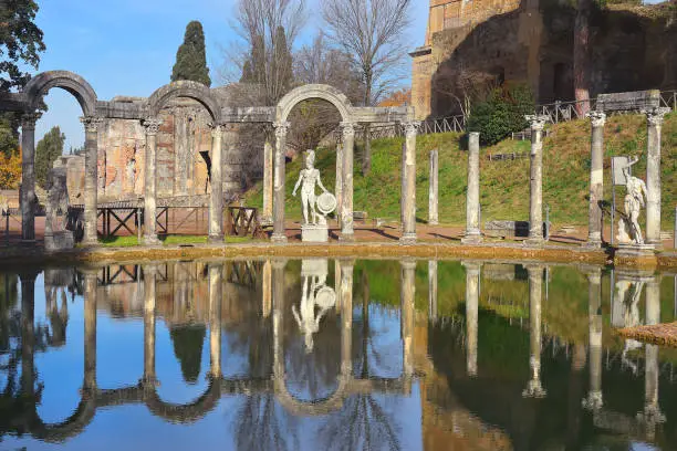 ancient pool called Canopus, surrounded by greek sculptures in Villa Adriana (Hadrian's Villa) and reflections in water in Tivoli, Italy