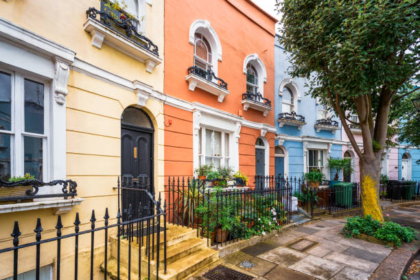 Colourful houses on a curving London street Houses painted in pastel colours in Chelsea, London. notting hill stock pictures, royalty-free photos & images