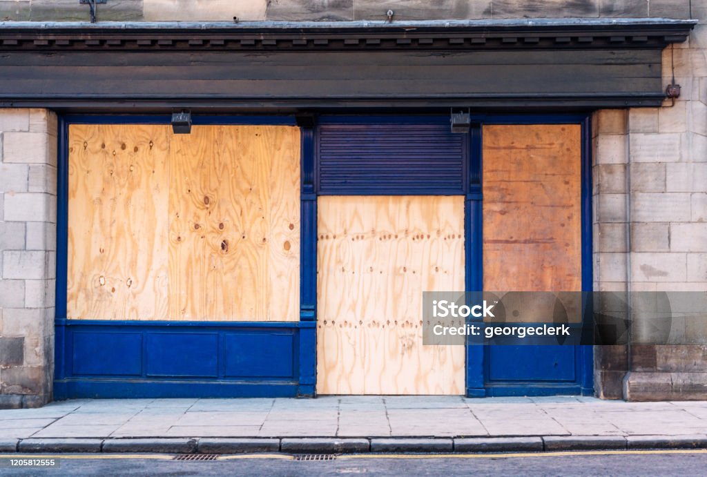 Boarded up shop A traditional British shopfront, closed and boarded up with wooden boards. Store Stock Photo