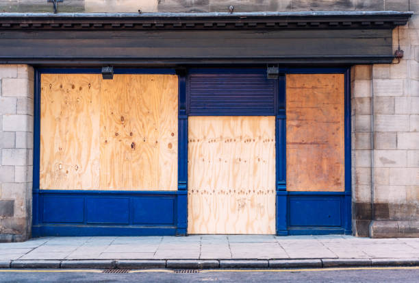 Boarded up shop A traditional British shopfront, closed and boarded up with wooden boards. abandoned stock pictures, royalty-free photos & images