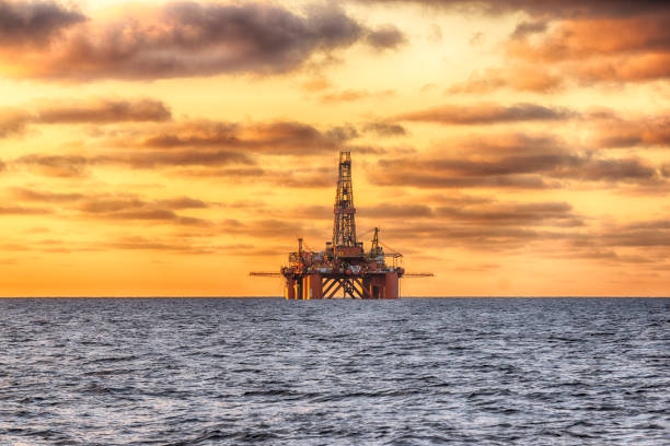 hdr de offshore jack up rig no meio do mar na hora do pôr do sol - oil pumping unit at sunset time - fotografias e filmes do acervo